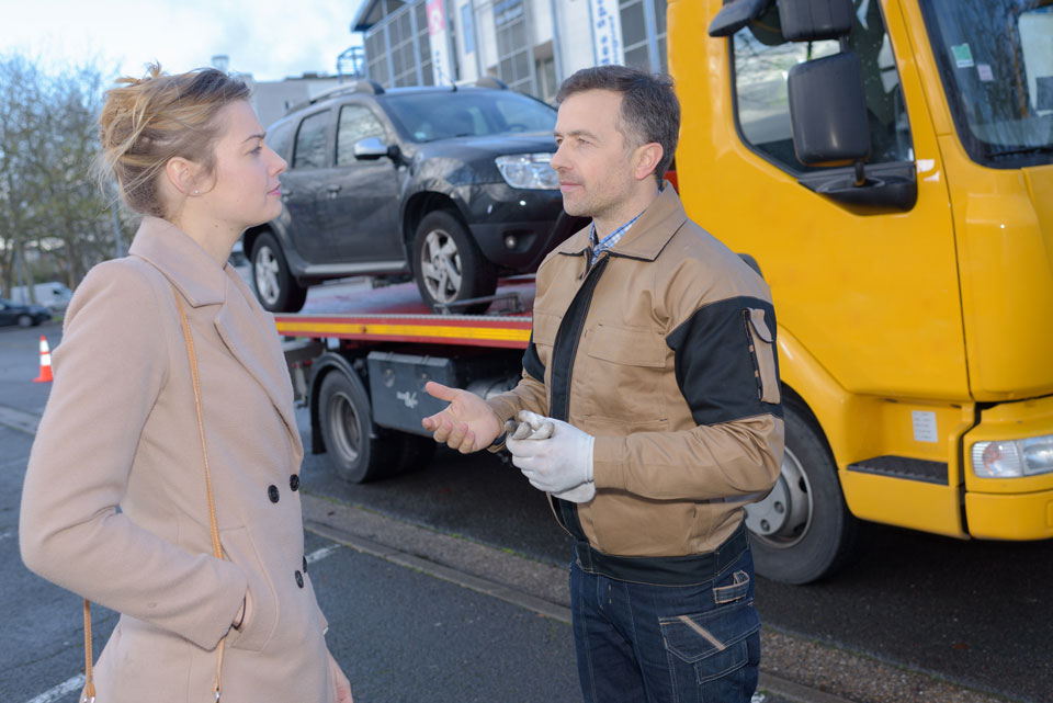 A good tow truck driver reassuring an anxious person