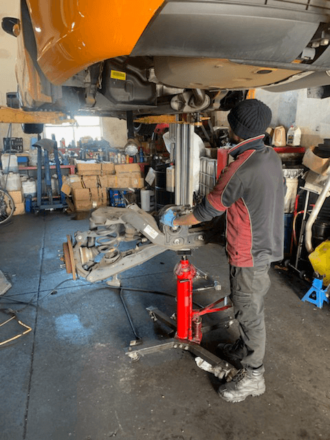 A car getting a full service including an oil change from a hoist