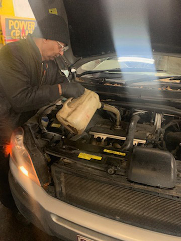 A mechanic changing the oil on a vehicle getting a service