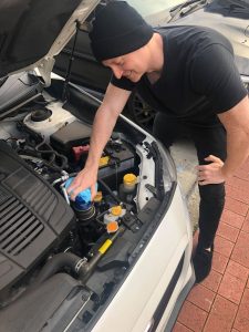 Hand on the oil filter getting ready to change out.