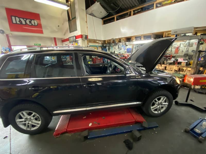 A car getting serviced in a workshop.