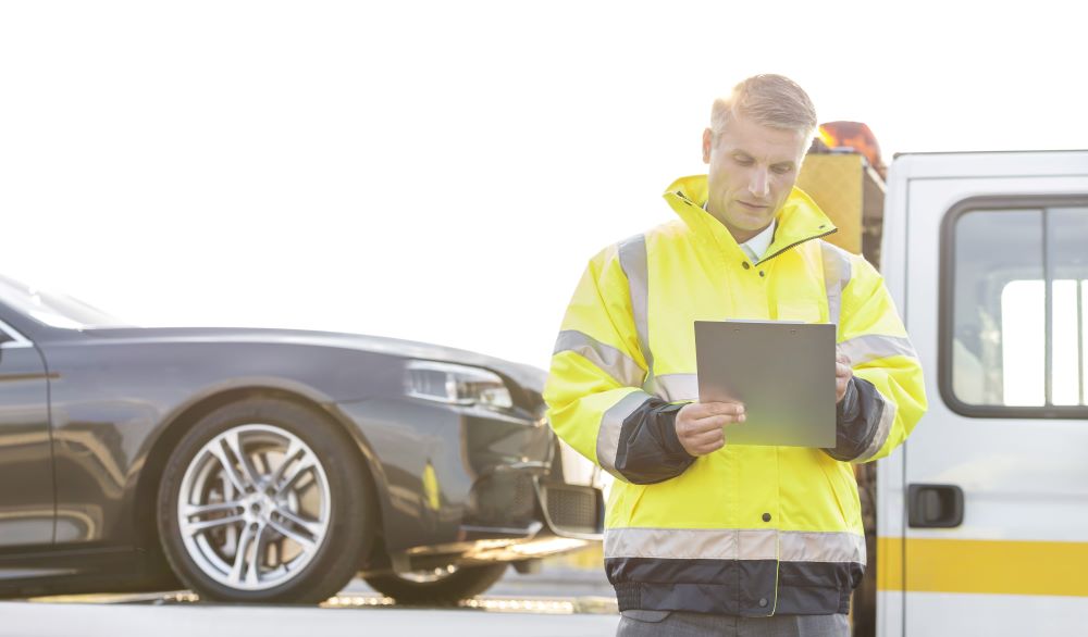 A tow truck driver checking documents.