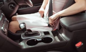 Woman fastening car seatbelt.