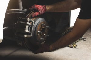 Car mechanic inspected disk brake and caliper.