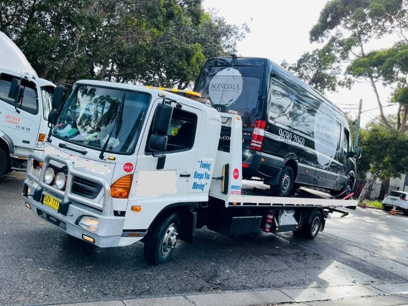 Van on the back of a tow truck