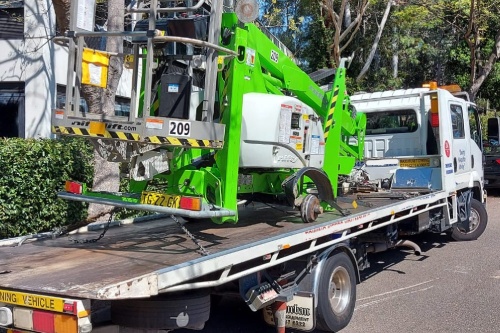 A tow truck transporting a large specialised piece of equipment