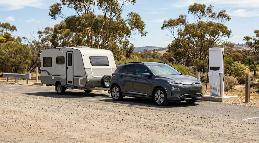 Electric vehicle towing a caravan parked near a charging station in regional Victoria near Melbourne